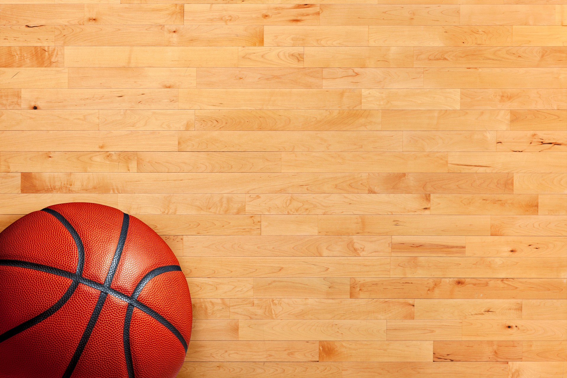 Basketball and hardwood basketball court floor viewed from above