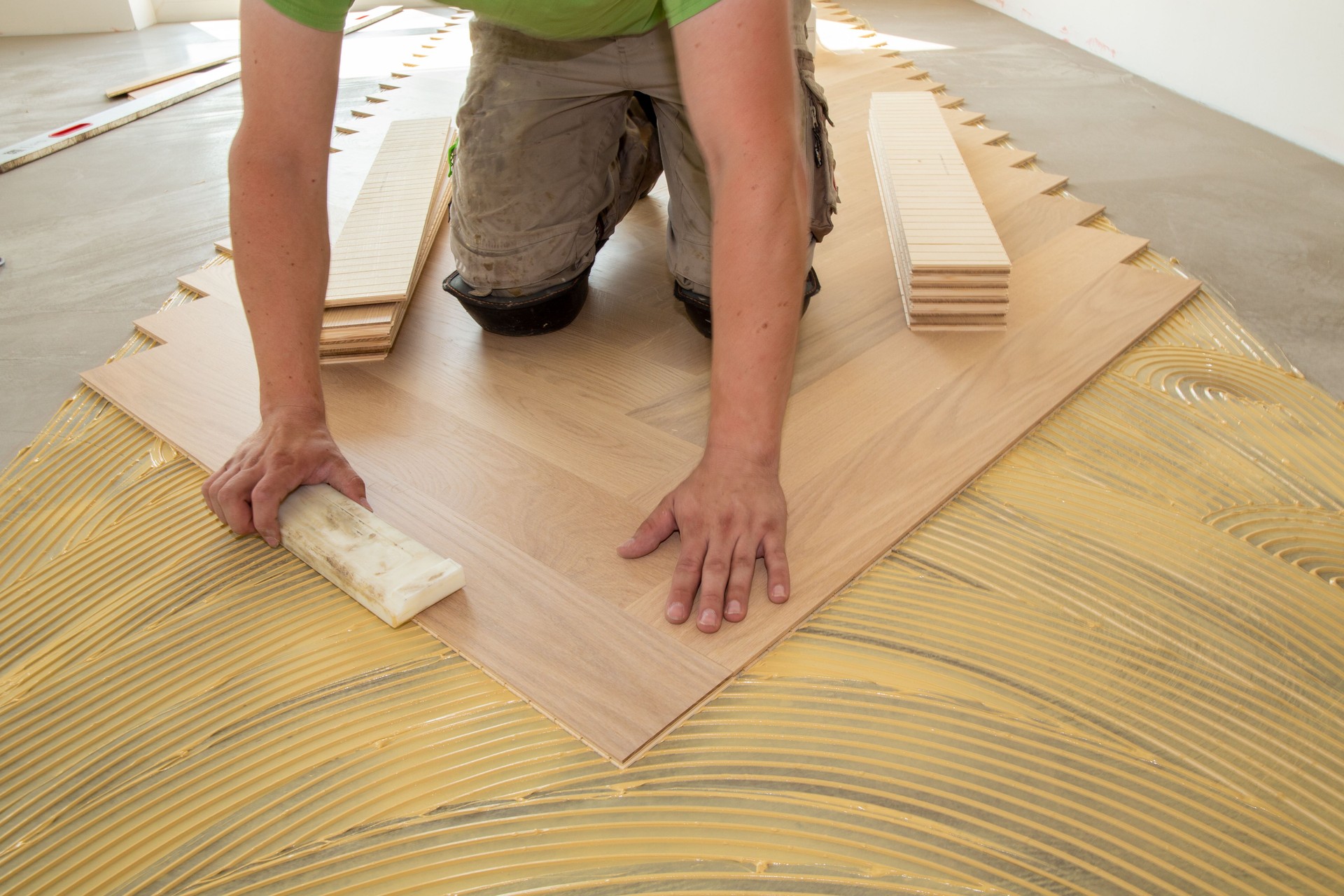 Craftsman laying herringbone parquet flooring professionally